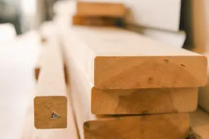 Drewniany domek 35 m² na etapie budowy, widoczne betonowe fundamenty punktowe z kotwami i żwirem w ogrodzie.