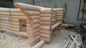 Drewniany domek 35 m² na etapie budowy, widoczne betonowe fundamenty punktowe z kotwami i żwirem w ogrodzie.